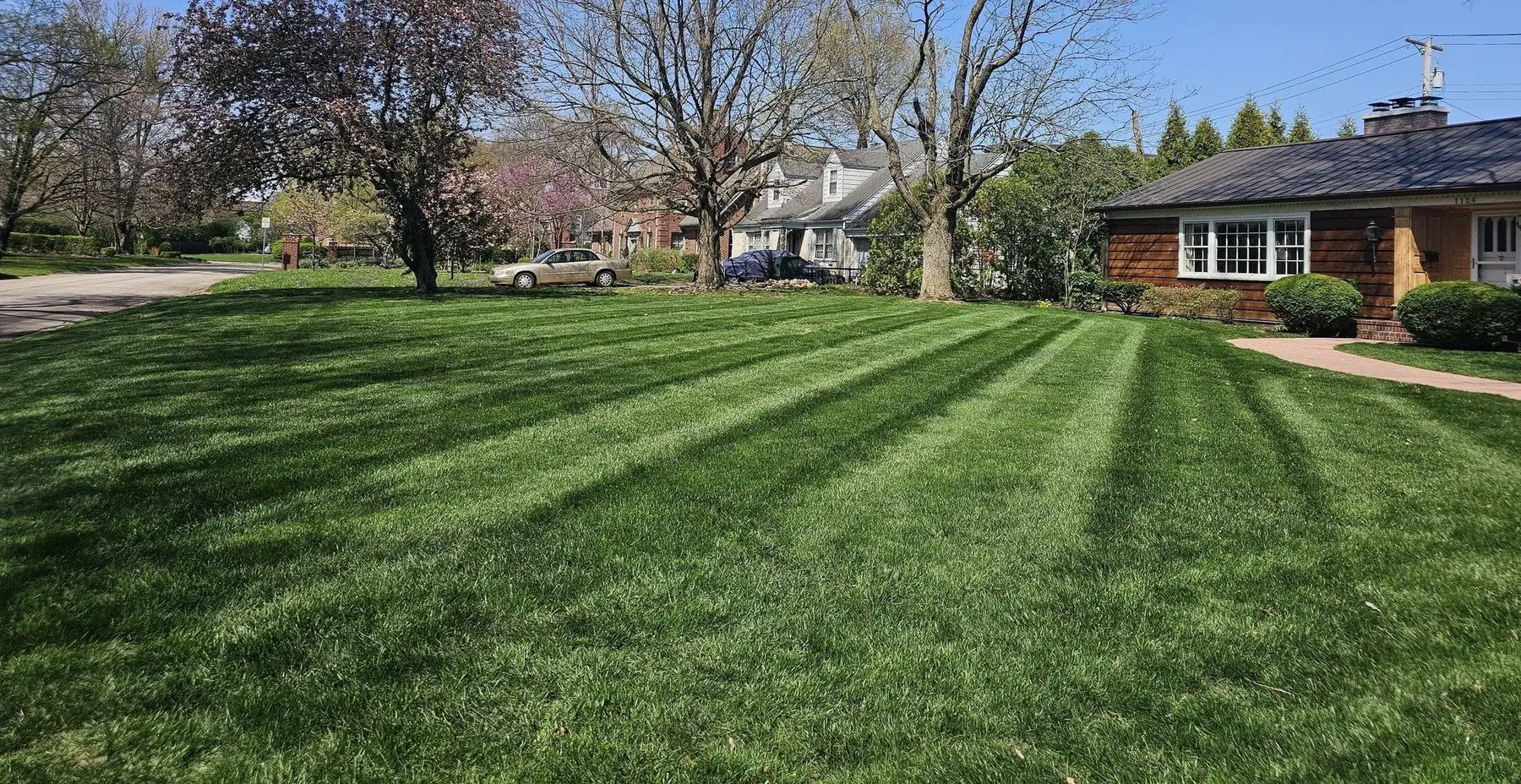 A freshly mowed lawn with clean diagonal stripes in front of a brick home in Muncie